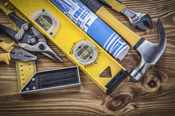 Collection of construction tools on wooden board top view