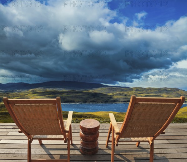 Two comfortable wooden sun loungers on the shore of the lake. Torres del Paine National Park. Summer in the south of Chile. The concept of extreme tourism