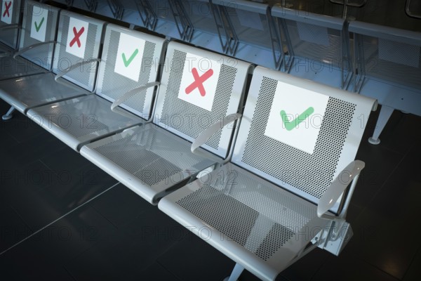 Empty chairs on an airport terminal with signs to keep social distance for the preventions of coronavirus covid 19 spread