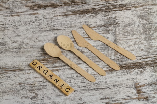 Rural wooden spoons and knives top view. Organic word made of cubes