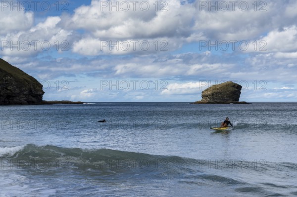 Portreath, United Kingdom, 4 September, lifeguard riding a wave on her emergency rescue board at Portreath Beach in northern Cornwall, Europe