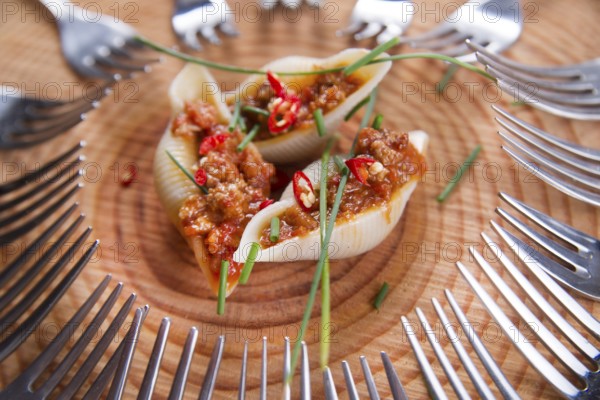 Presentation first plate of pasta shells with meat sauce and tomato