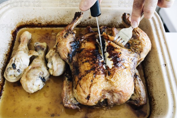 Woman carving homemade whole roasted chicken on plate