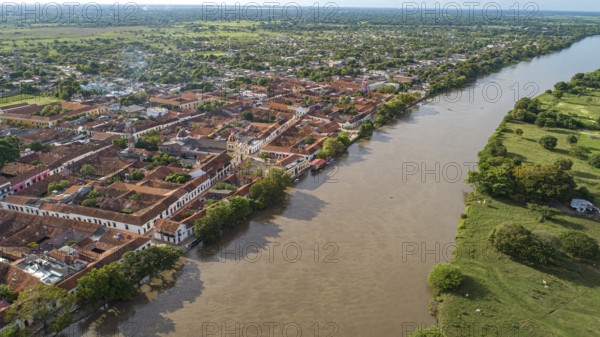 Aerial view of the historic town Santa Cruz de Mompox in sunlight with river and green sourrounding, World Heritage