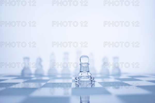 A photo of pawns standing in front of a chess set of the same colour