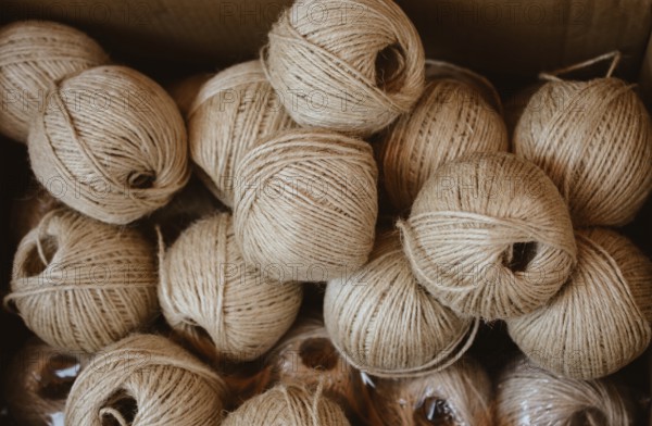 Plenty of spools or rolls of brown color linen string