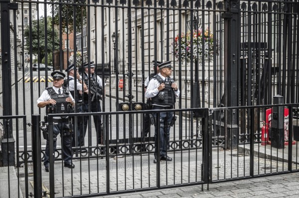London, UK, August 18, 2015: Police officers protecting the gate of Downing street in London, the residence of the prime minister