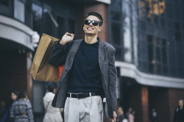 Serious cool guy with sunglasses and paper bags walking at street