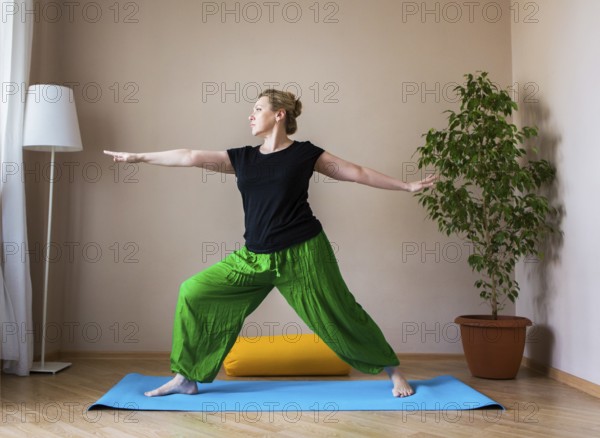 Middle aged or mature woman doing yoga indoors
