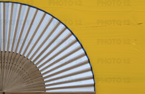 Typical Japanese hand fan made on the wooden yellow table