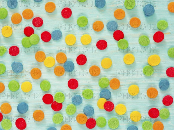 Border frame of colorful sprinkles on blue background. Top view or flat lay