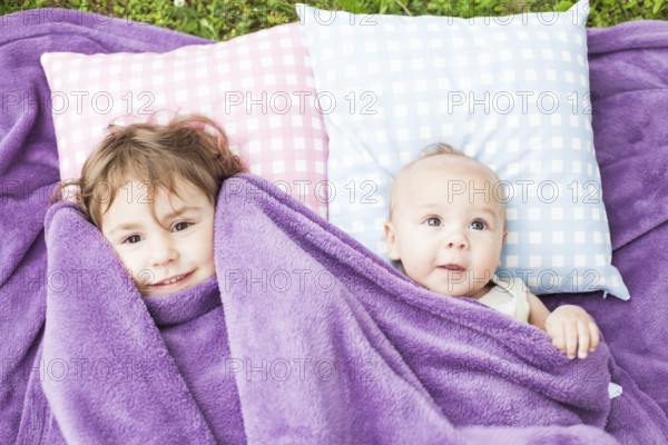 Sister and brother play on the pillows