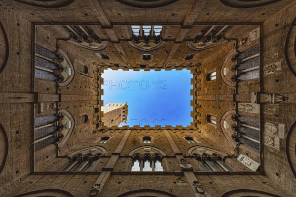 View into the sky of the Torre del Mangia, through a historic courtyard, Palazzo Pubblico, Siena, Tuscany, Italy, Europe