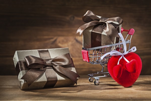 Two vintage gift boxes in shopping cart and heart toy