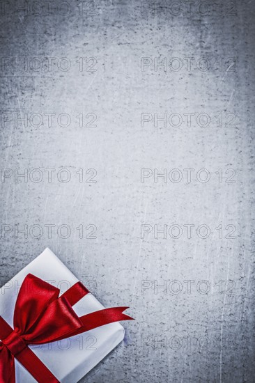 Present with red bow on metallic background copyspace holidays concept