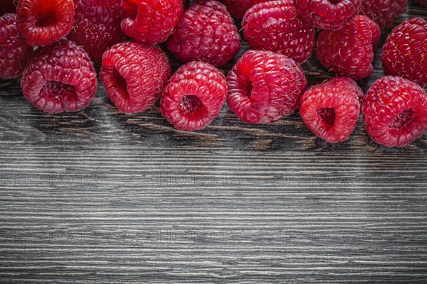 Raspberries on wooden background top view