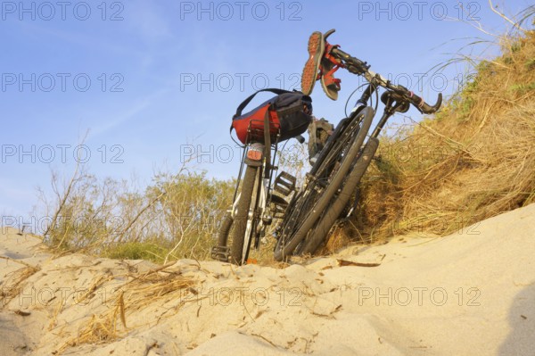 Two bicycles on the sea sand, a Bicycle in the sunset rays, Curonian spit, Zelenograd district, Kaliningrad region, Russia, August 31, 2019, Europe