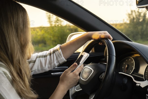 Womandriver using mobile phone paying for parking and navigating in the city while stopped on the side of the road. Self road trip, technology, travel and people concept