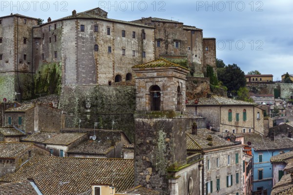 Italy, southern Tuscany. The tufa city of Sorano is a enchanted city from a fairy tale. Tiled roofs of houses, narrow streets amidst gloomy stone walls. The concept of active, historical and photo tourism, Europe