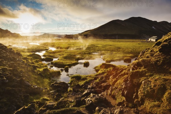 Above the source of thermal water steam rises. White nights in Iceland. Sunrise Park Landmannalaugar