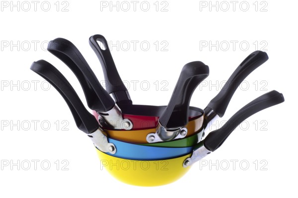 Many stacked colorful frying pans isolated over white