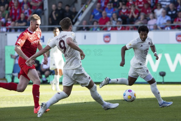 Football match, Harry KANE Bayern Munich centre passes the ball to Serge GNABRY Bayern Munich right, captain Patrick MAINKA 1.FC Heidenheim left is too late, Voith-Arena football stadium, Heidenheim