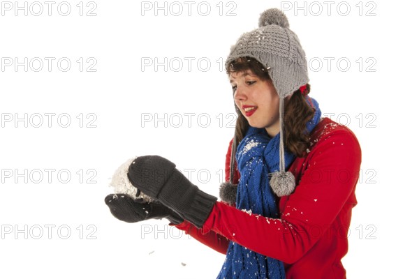 Winter girl in red and blue is throwing snow ball