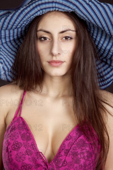 Pretty young girl face in hat on dark background