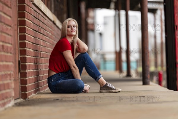 A beautiful blonde woman poses joyfully for the camera, showcasing her stylish spring clothing. With a bright smile and playful demeanor, she radiates happiness, embracing the upcoming gorgeous weather, Charlotte, United States of America
