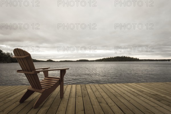 Known as Muskoka or Adirondack chairs sit on a dock at a resort in Muskoka, Ontario, Canada, North America