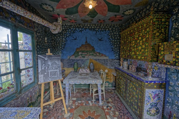 Colorfully decorated room with intricate mosaic artworks, paintings, a table, and chairs, Tourist place photographed by Robert Doisneau, Chartres, Eure-et-Loir, France, Europe
