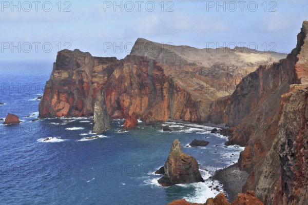 Red rocks and blue sea. Eastern end of Madeira Island at sunset. Deep Bay with picturesque islands - rocks