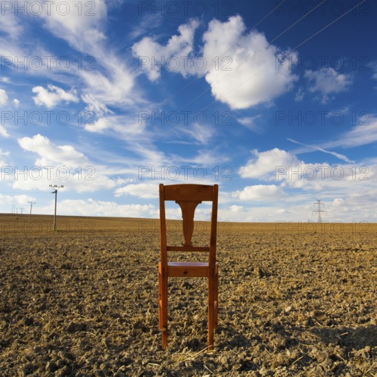 Old wooden chair on the empty field after harvest