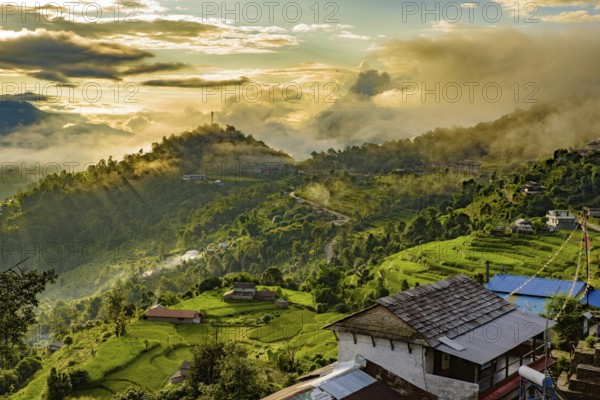 A village on the mountains under the light of sunrise through clouds