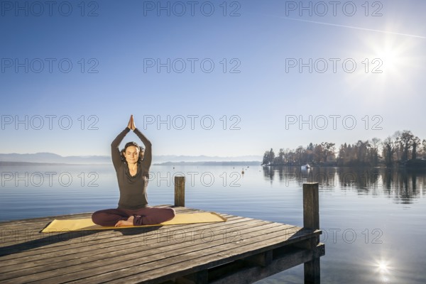 An image of a pretty woman doing yoga at the lake