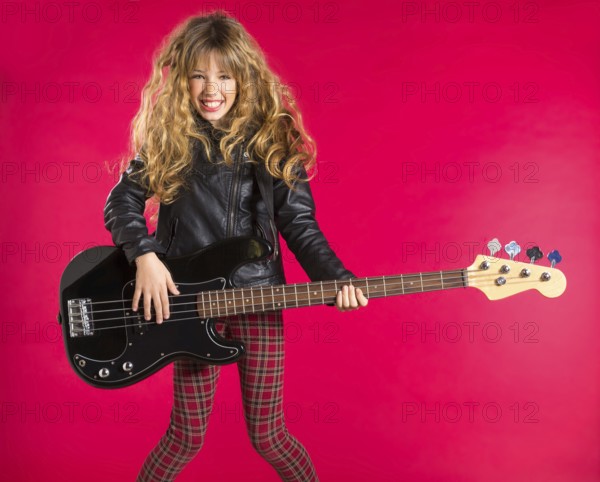 Blond Rock and roll girl playing bass guitar on red background