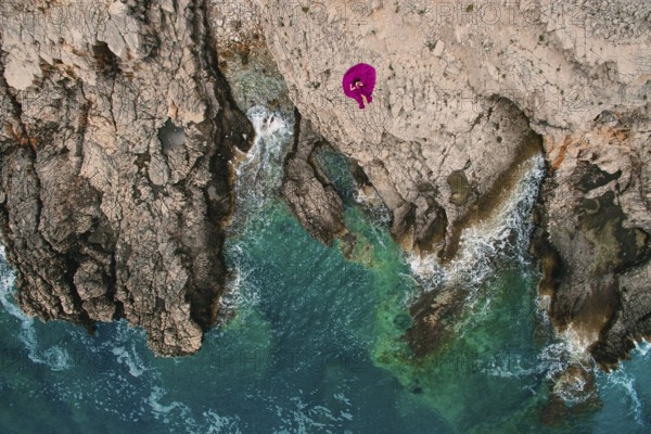 A girl in a purple dress rests on a rocky beach in Montenegro, aerial photography, Herceg Novi, Montenegro, Europe