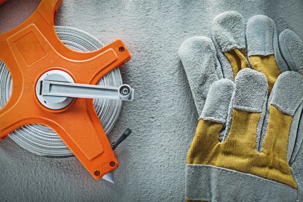 Set of protective gloves measuring tape on concrete background