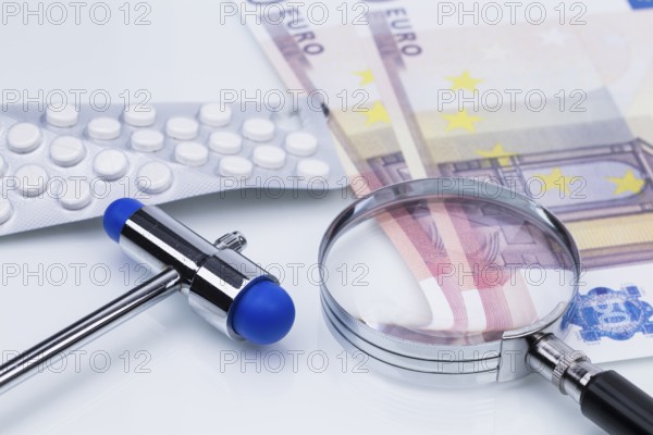 The photo shows a pack of tablets with a magnifying glass and money