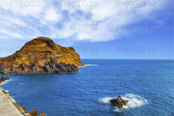 Calm bay with azure water. Rocks and stones off the shores of the volcanic island of Madeira. The concept of ecological and exotic tourism