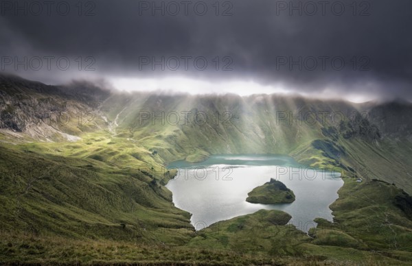 Sunrays through clouds over alpine lake, Schrecksee, Germany, Europe