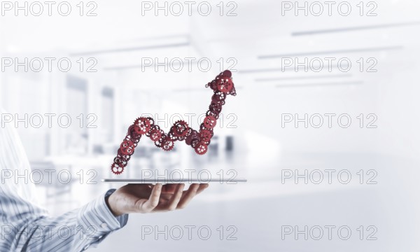 Growing graph made of gears and cogwheels on white office background. Mixed media