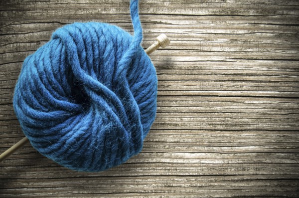 Retro Style Image Of A Ball Of Wool And Knitting Needle On A Rustic Wooden Table