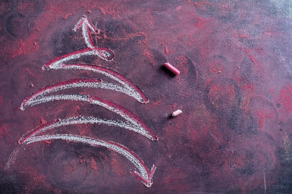 Graphical representation of a Christmas tree drawn with chalk on blackboard