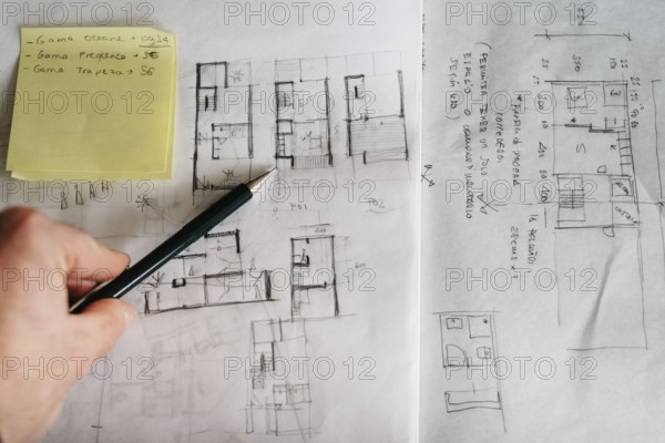 Man architect drawing plan or design by pencil on paper at office desk