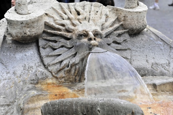 Stone fountain with face sculpture from which water flows, Rome, Lazio, Italy, Europe