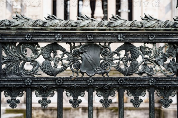 Antique wrought iron fence near the Duomo Cathedral in Milan with spikelets, shields, flowers and curls.