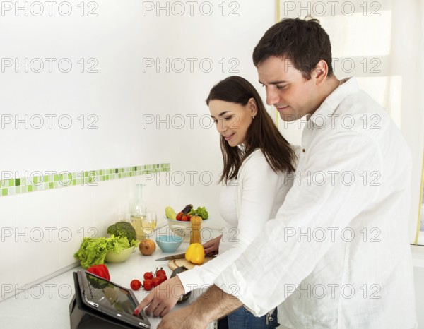 Portrait of a happy couple preparing food in the kitchen