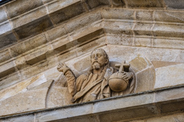 Detail of the pediment of the entrance portico of Zamora Cathedral with sculpture of Christ holding the sphere with a cross