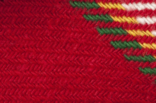 Handmade knit green and red background. Close up structure of the yarn. Christmas colors